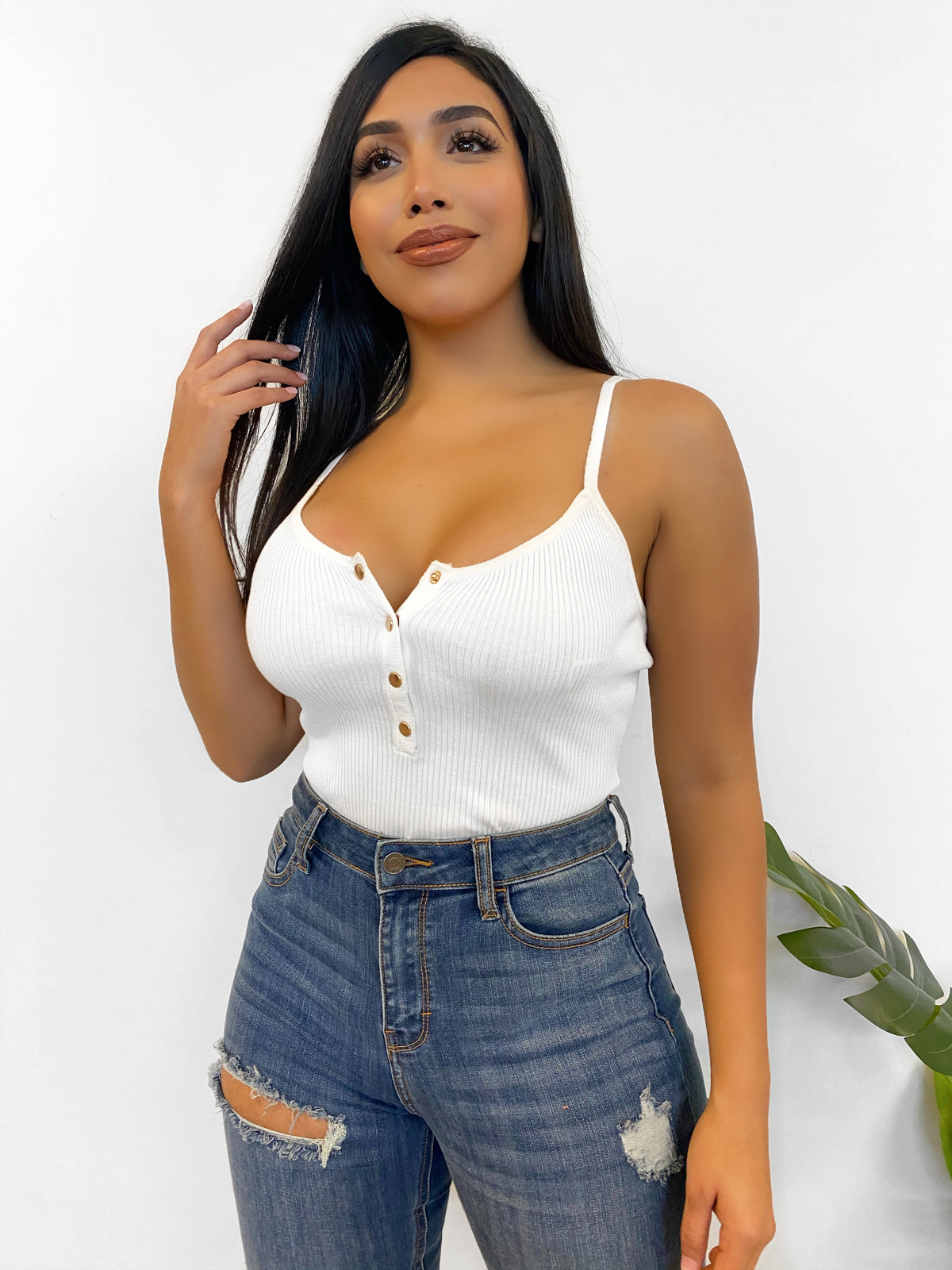SPAGHETTI STRAP BODYSUIT, RIBBED MATERIAL, STRETCHY, MID CLEAVAGE SHOWING, MID BACK SHOWING, GOLD BUTTONS DOWN THE MIDDLE FRONT, COLOR IS WHITE.