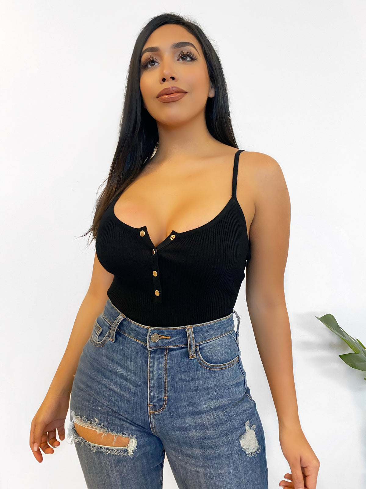 SPAGHETTI STRAP BODYSUIT, RIBBED MATERIAL, STRETCHY, MID CLEAVAGE SHOWING, MID BACK SHOWING, GOLD BUTTONS DOWN THE MIDDLE FRONT, COLOR IS BLACK.